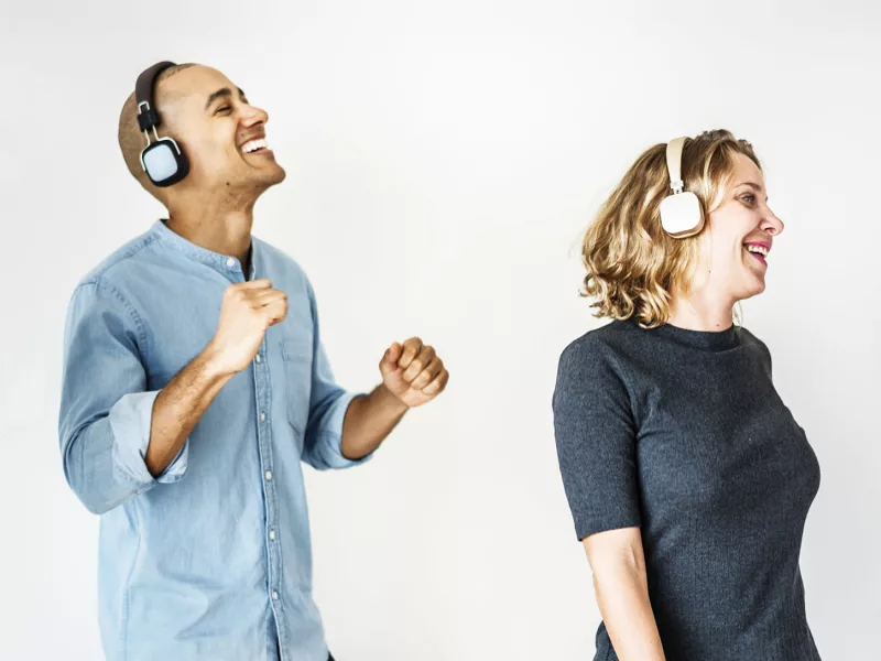 Foto eines Mannes und einer Frau, die sich freuen und Kopfhörer aufhaben