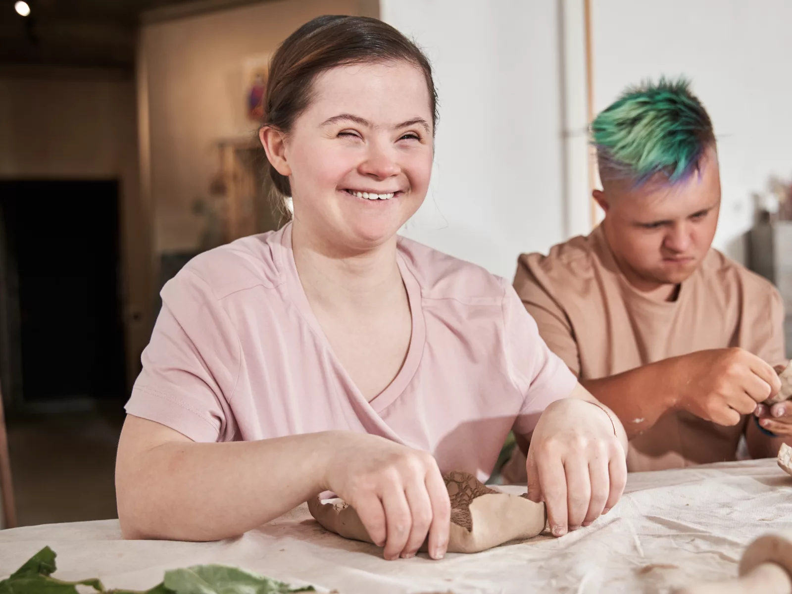 Zwei Jugendliche mit Beeinträchtigung bei der Arbeit am Tisch